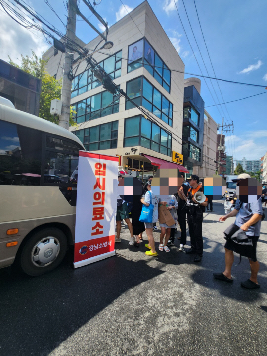 26일 강남구 티몬 별관 앞에 마련된 임시진료소 옆에 마련된 생수 공급대에 사람들이 몰려들고 있다.  김수연기자 newsnews@dt.co.kr